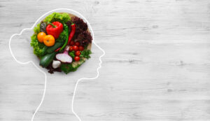 canada food guide effectiveness: food fuels our minds and bodies. An outline of the side profile of a woman's head, filled with vegetables.